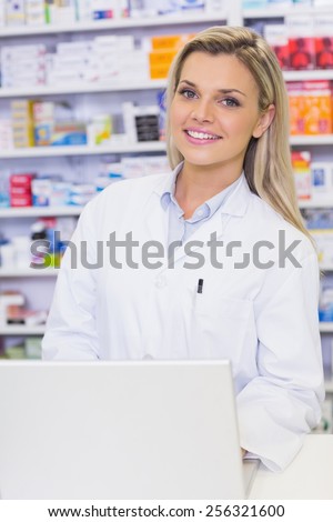 Smiling pharmacist looking at camera at the hospital pharmacy