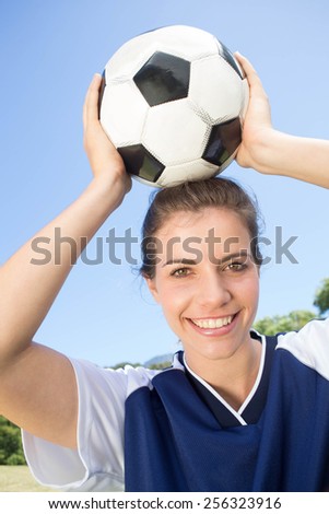 Pretty football player smiling at camera on a sunny day