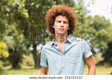 Young man looking at camera in park on a sunny day