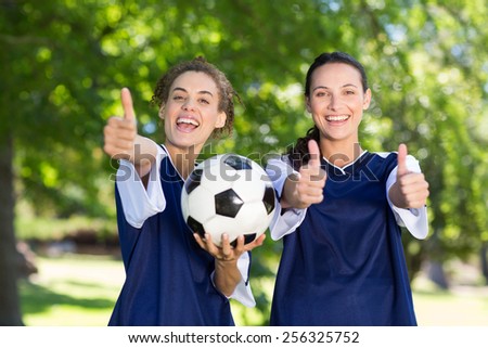 Pretty football players smiling at camera on a sunny day