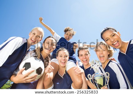 Pretty football players smiling at camera on a sunny day