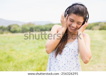 Pretty brunette listening to music on a sunny day