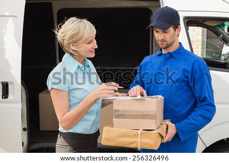Delivery driver showing where to sign to customer outside the warehouse