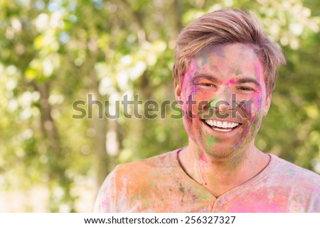 Happy man covered in powder paint on a sunny day