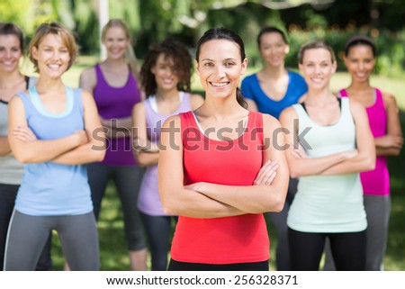 Fitness group smiling at camera in park on a sunny day