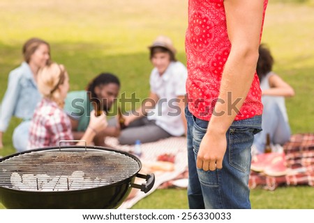 Happy friends in the park having barbecue on a sunny day