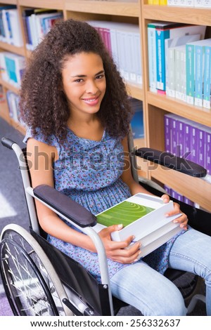 Smiling disabled student in library at the university