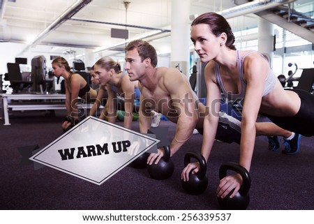 The word warm up and fitness class in plank position with kettlebells against badge
