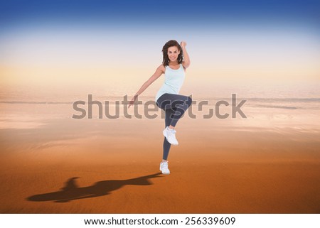 Fit woman doing aerobic exercise against hazy blue sky