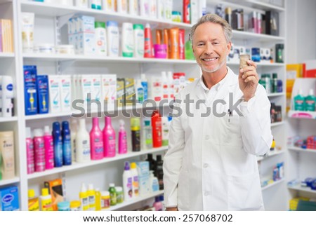 Senior pharmacist holding medicine jar in the pharmacy