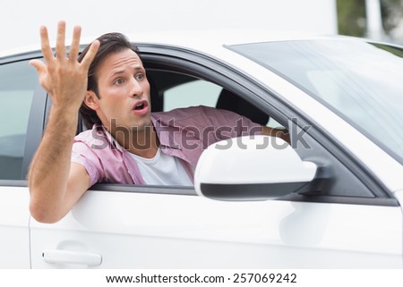 Young man experiencing road rage in his car