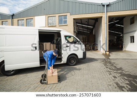 Delivery driver packing his van in a large warehouse