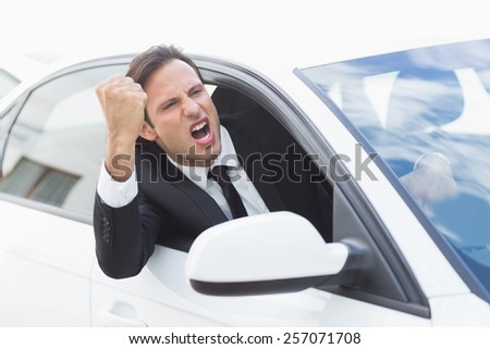 Businessman experiencing road rage in his car
