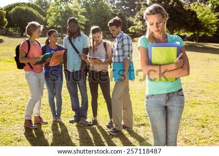 Student being bullied by a group of students on a sunny day
