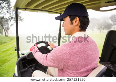Golfer driving his golf buggy at the golf course
