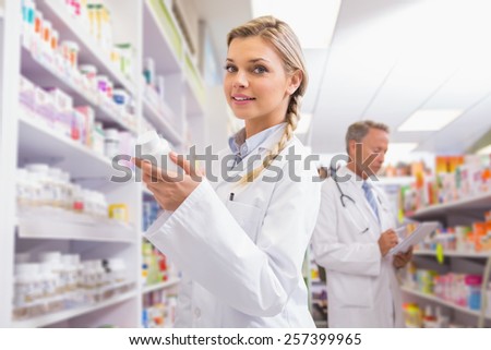 Smiling student holding medicine in the pharmacy