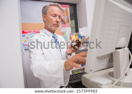 Senior pharmacist using the computer in the pharmacy