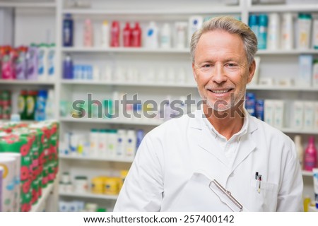 Senior pharmacist holding a clipboard in the pharmacy