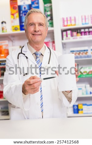 Smiling senior doctor pointing paper in the pharmacy