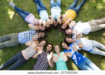 Happy friends in the park lying in circle on a sunny day