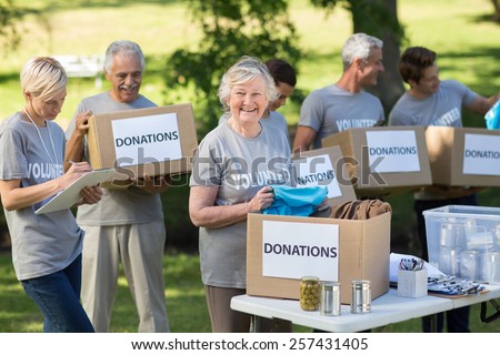 Happy family holding donations boxes on a sunny day