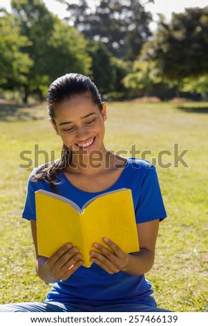 Woman reading book in park on a sunny day