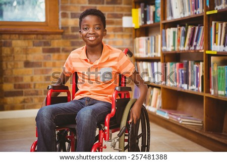 Portrait of little boy sitting in wheelchair at the library