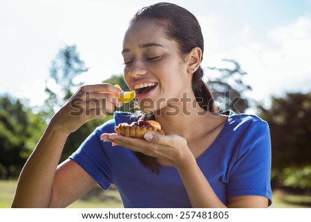 Pretty woman eating pizza in the park on a sunny day