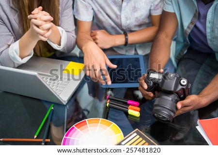 Close up of creative business people with digital camera at office desk