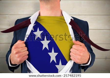 Businessman opening shirt to reveal bosnia flag against bleached wooden planks background