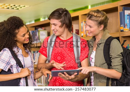 Group of college students using digital tablet in the library