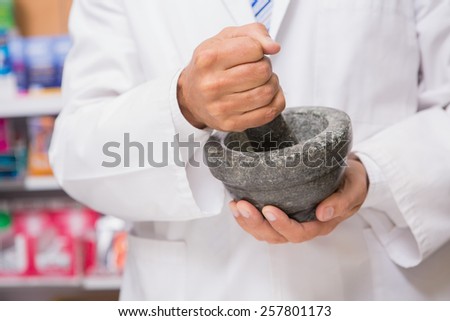Pharmacist in lab coat mixing a medicine in the pharmacy