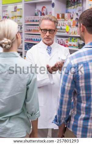 Senior pharmacist explaining the pills to patient at pharmacy