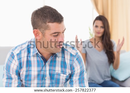 Tensed man looking at woman fighting with him at home