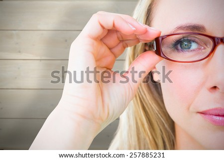 Close up of pretty blonde with red reading glasses against bleached wooden planks background