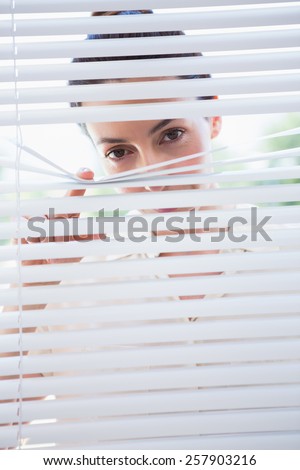 Woman peeking through blinds from outside