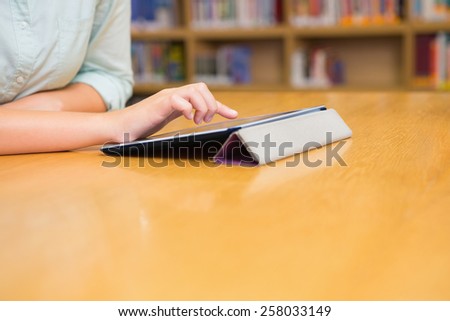Student studying in the library with tablet at the university