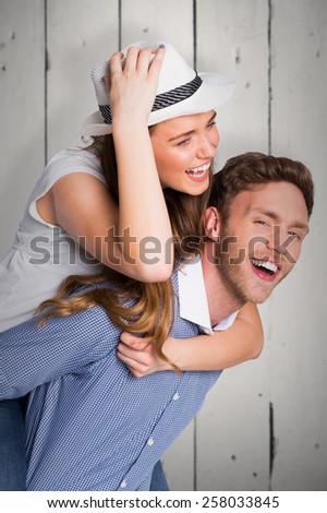 Smiling young man carrying woman against white wood