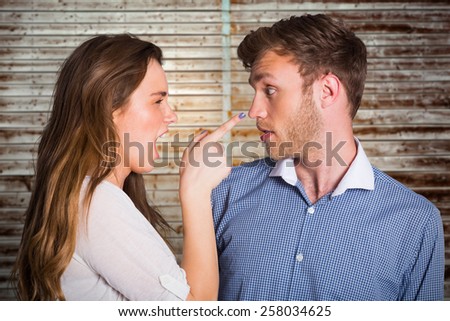 Casual young couple in an argument against wooden planks