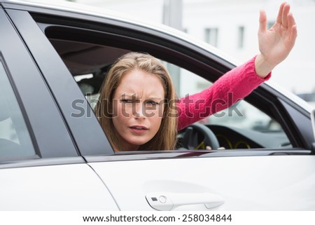 Young woman experiencing road rage in her car