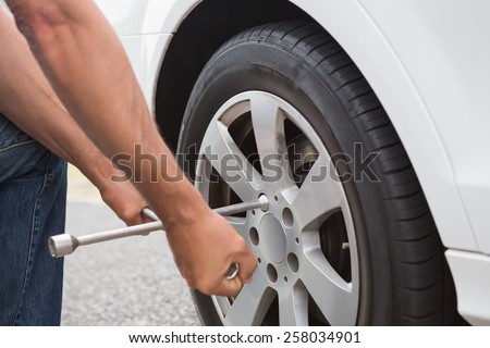 Man fixing tire of his car