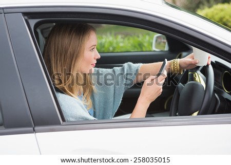 Young woman having a coffee in her car