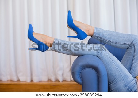 Womans legs in high heels in the living room