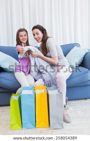 Mother and daughter looking at shopping bags at home in the living room