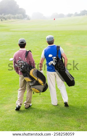 Golfer friends walking and chatting at the golf course