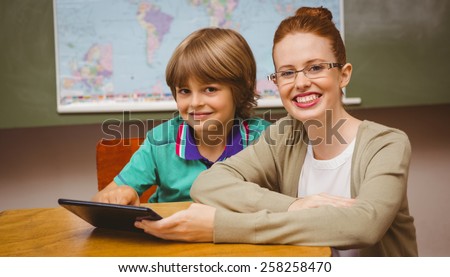 Portrait of female teacher and boy using digital tablet in the classroom