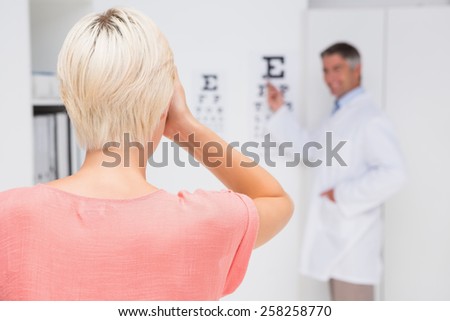 Blonde woman doing eye exam in medical office