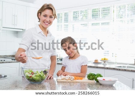 Mother and daughter preparing vegetables at home in kitchen