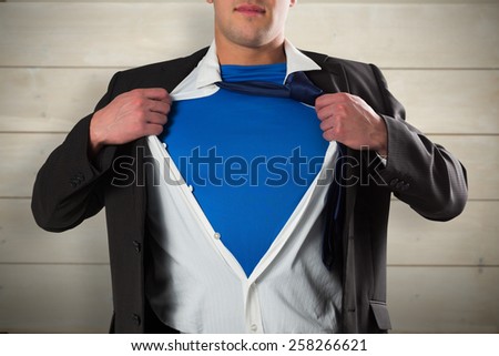 Businessman opening his shirt superhero style against bleached wooden planks background