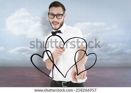 Geeky hipster pointing at camera against clouds in a room